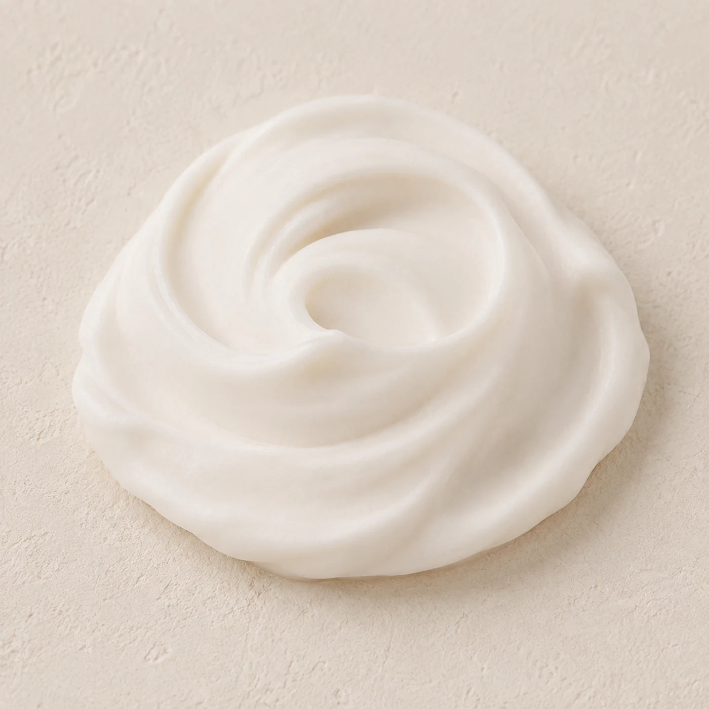A swirl of Collagen Face Cream on a warm stone surface