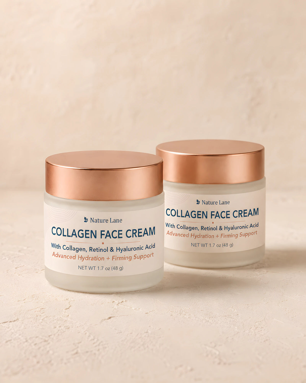 Two jars of Nature Lane Collagen Face Cream, lids closed, standing together on a warm plaster surface.